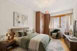 Step into this inviting bedroom, featuring a cozy bed adorned with soft bedding and pillows.