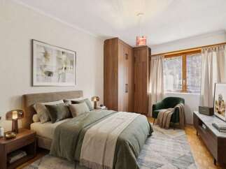 Step into this inviting bedroom, featuring a cozy bed adorned with soft bedding and pillows.