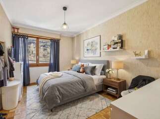 This cozy bedroom features a comfortable bed with soft bedding and a stylish rug.
