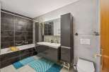 Step into a modern bathroom oasis! This stunning space features sleek gray tiles, a double vanity, and ample storage.