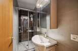 Step into this modern bathroom, featuring a sleek shower enclosure and a stylish vanity.