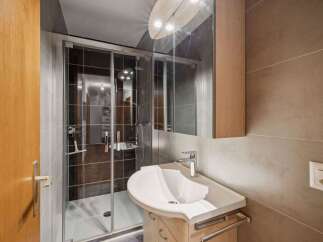 Step into this modern bathroom, featuring a sleek shower enclosure and a stylish vanity.