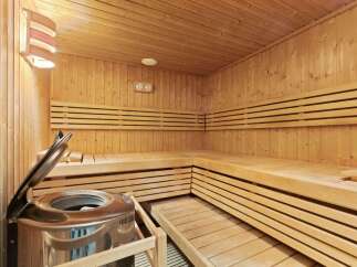 Step into relaxation with this stunning sauna! Featuring beautiful wooden benches and walls, this space offers the perfect escape for unwinding.