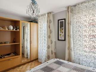 This cozy bedroom features a stylish wooden wardrobe with ample storage and a built-in mirror, perfect for organizing your belongings.