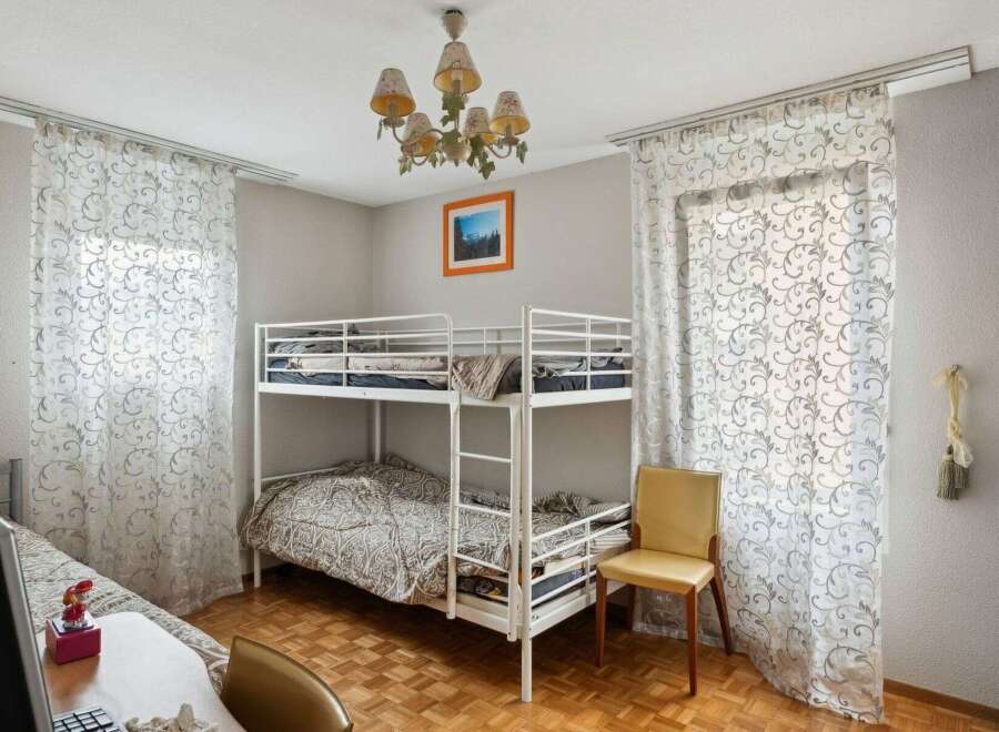 Discover this charming bedroom featuring a cozy bunk bed, perfect for accommodating guests or family members.