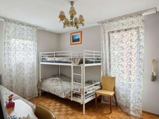 Discover this charming bedroom featuring a cozy bunk bed, perfect for accommodating guests or family members.