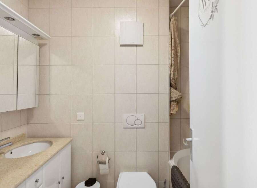 This bathroom features a clean and modern design with neutral-colored tiles.