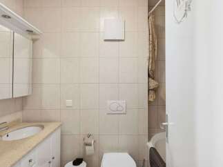 This bathroom features a clean and modern design with neutral-colored tiles.