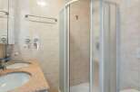 This bathroom features a modern shower with a glass door, offering a sleek and contemporary design.
