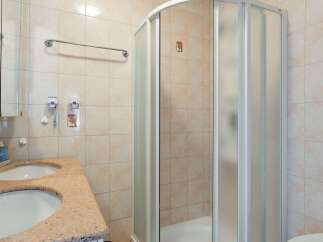 This bathroom features a modern shower with a glass door, offering a sleek and contemporary design.