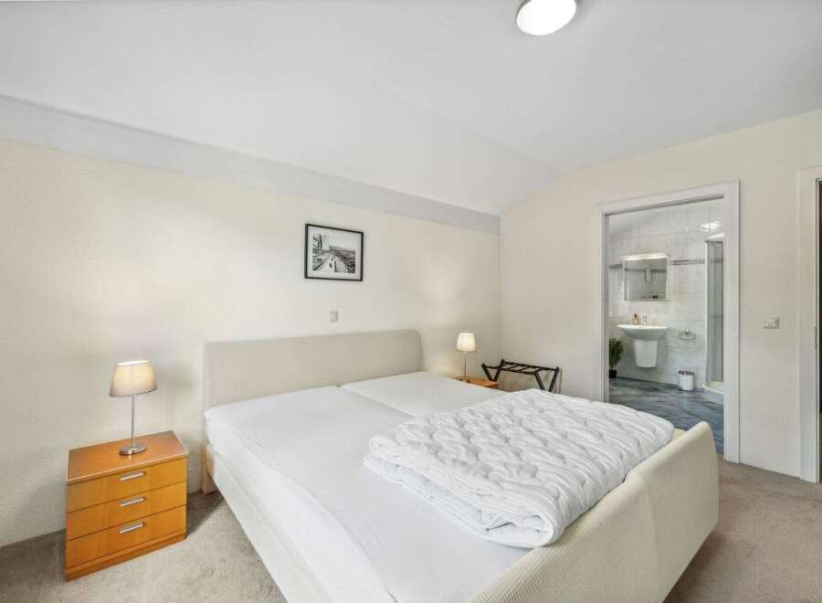 This inviting bedroom features a comfortable bed with a cozy duvet, perfect for a relaxing stay.