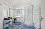 Step into this bright and airy bathroom, featuring a modern shower and a sleek pedestal sink.
