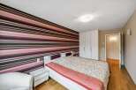 This stylish bedroom features a striking striped accent wall, creating a bold and modern aesthetic.