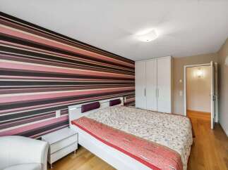 This stylish bedroom features a striking striped accent wall, creating a bold and modern aesthetic.