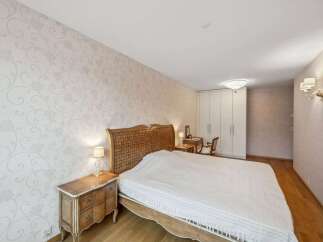 This elegant bedroom features a stunning woven headboard and a cozy bed, perfect for relaxation.