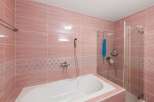 Step into this beautifully designed bathroom, featuring elegant pink tiles that create a serene and inviting atmosphere.