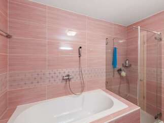 Step into this beautifully designed bathroom, featuring elegant pink tiles that create a serene and inviting atmosphere.