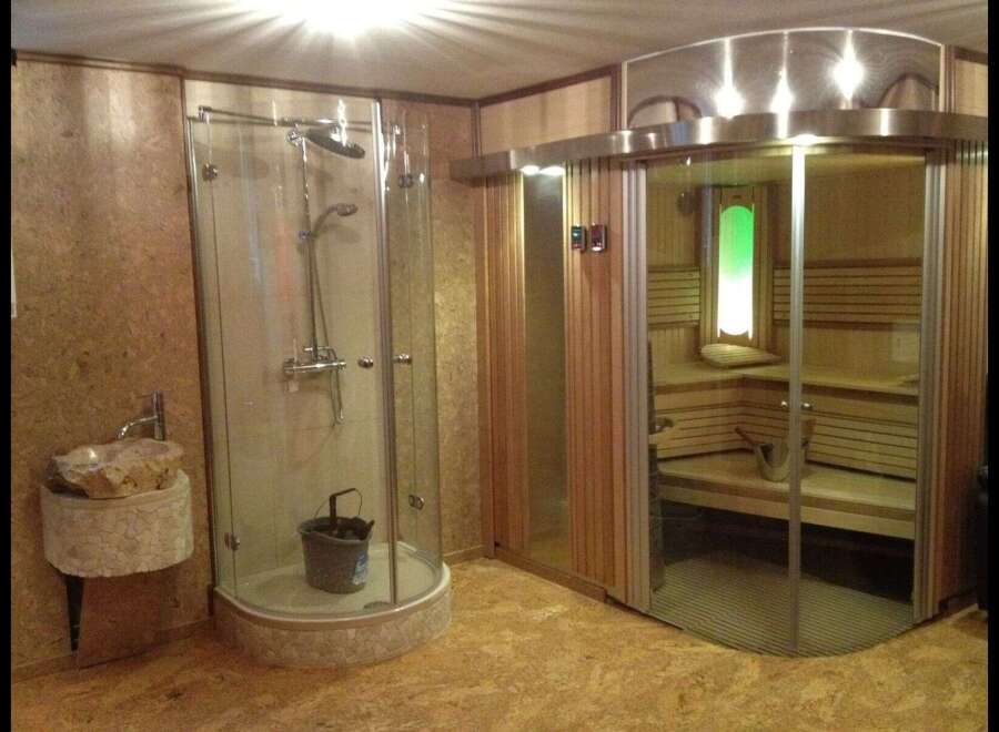Step into luxury with this spa-like bathroom featuring a modern shower and a relaxing sauna.