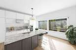 This stunning kitchen boasts a modern design with sleek white cabinetry and a beautiful marble countertop.