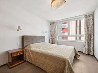 This cozy bedroom features a comfortable bed with a neutral-toned quilt, perfect for a relaxing retreat.