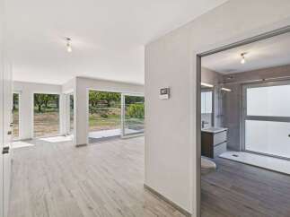 Experience modern living in this spacious home featuring expansive windows that flood the interior with natural light and offer picturesque views of the surrounding greenery.