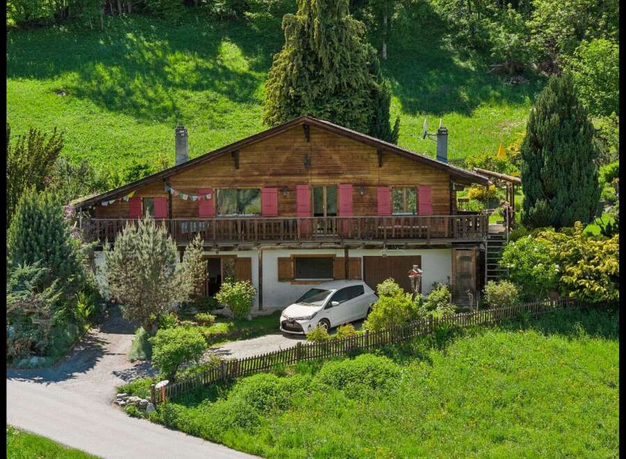 Nestled in a serene, green landscape, this charming wooden house offers a perfect blend of rustic charm and modern comfort.