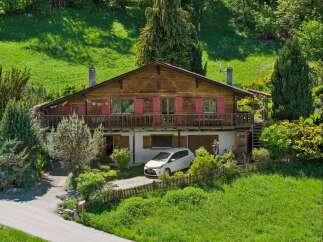 Nestled in a serene, green landscape, this charming wooden house offers a perfect blend of rustic charm and modern comfort.