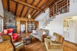 This charming property boasts a cozy living space with a rustic wooden ceiling and a brick fireplace, creating a warm and inviting atmosphere.