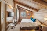 Experience the charm of this cozy bedroom featuring a rustic wooden interior and a comfortable bed.