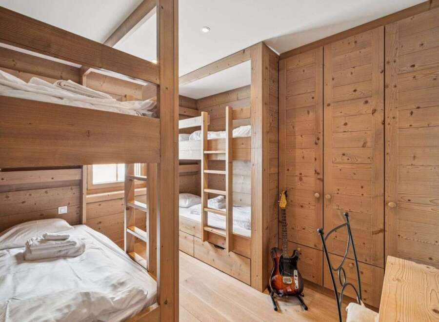 This cozy bedroom features custom-built wooden bunk beds, perfect for accommodating guests or family members.