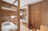 This cozy bedroom features custom-built wooden bunk beds, perfect for accommodating guests or family members.
