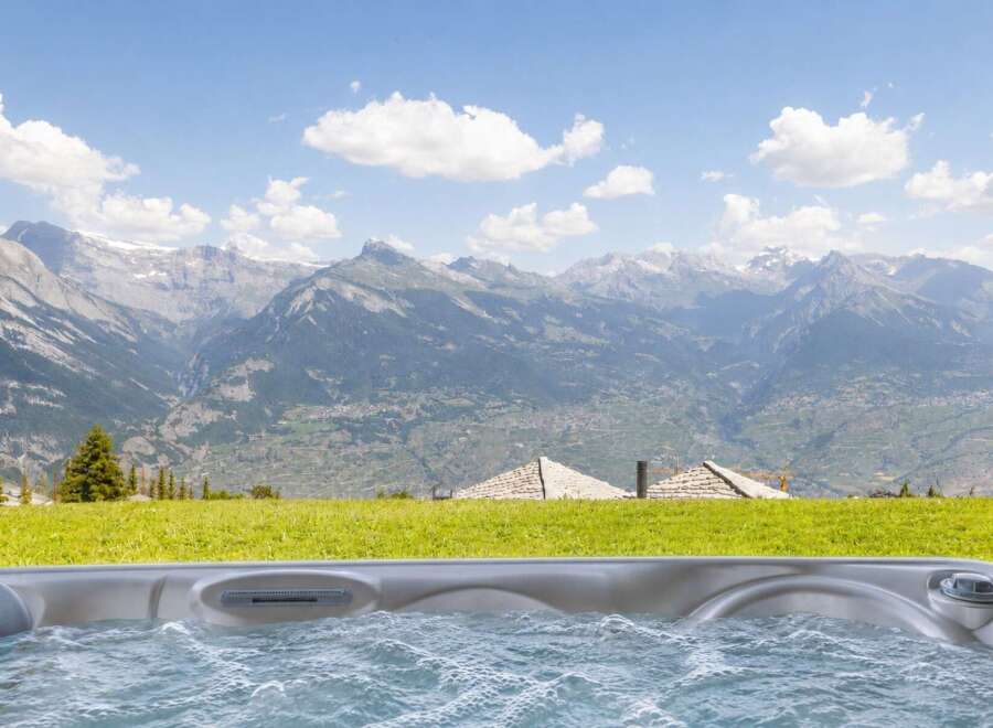 Experience ultimate relaxation with this stunning hot tub, offering breathtaking panoramic views of majestic mountains.