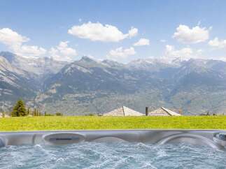Experience ultimate relaxation with this stunning hot tub, offering breathtaking panoramic views of majestic mountains.