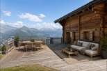 Experience breathtaking mountain views from this stunning wooden chalet's expansive deck.