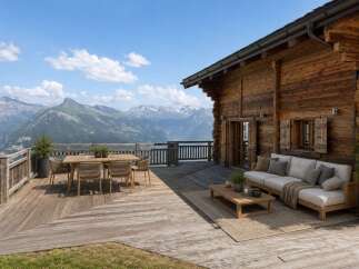 Experience breathtaking mountain views from this stunning wooden chalet's expansive deck.