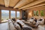 Experience breathtaking mountain views from this stunning alpine retreat, featuring a cozy living room with a modern fireplace and expansive windows.