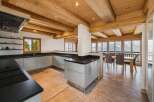 Experience luxury mountain living in this stunning kitchen and dining area, featuring a modern L-shaped kitchen with sleek cabinetry and a spacious island.