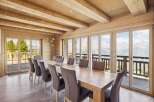 Experience breathtaking mountain views from this stunning dining room, featuring a large wooden table and comfortable upholstered chairs.