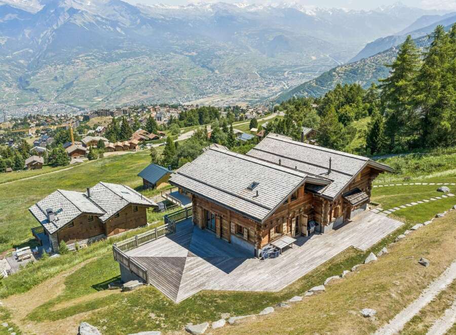 Experience luxurious mountain living in this stunning wooden chalet, boasting expansive decks with breathtaking panoramic views of the valley and snow-capped peaks.