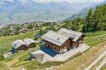 Experience luxurious mountain living in this stunning wooden chalet, boasting expansive decks with breathtaking panoramic views of the valley and snow-capped peaks.