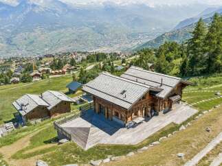 Experience luxurious mountain living in this stunning wooden chalet, boasting expansive decks with breathtaking panoramic views of the valley and snow-capped peaks.