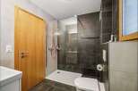 Step into this modern bathroom, featuring a sleek glass-enclosed shower and stylish dark tile accents.