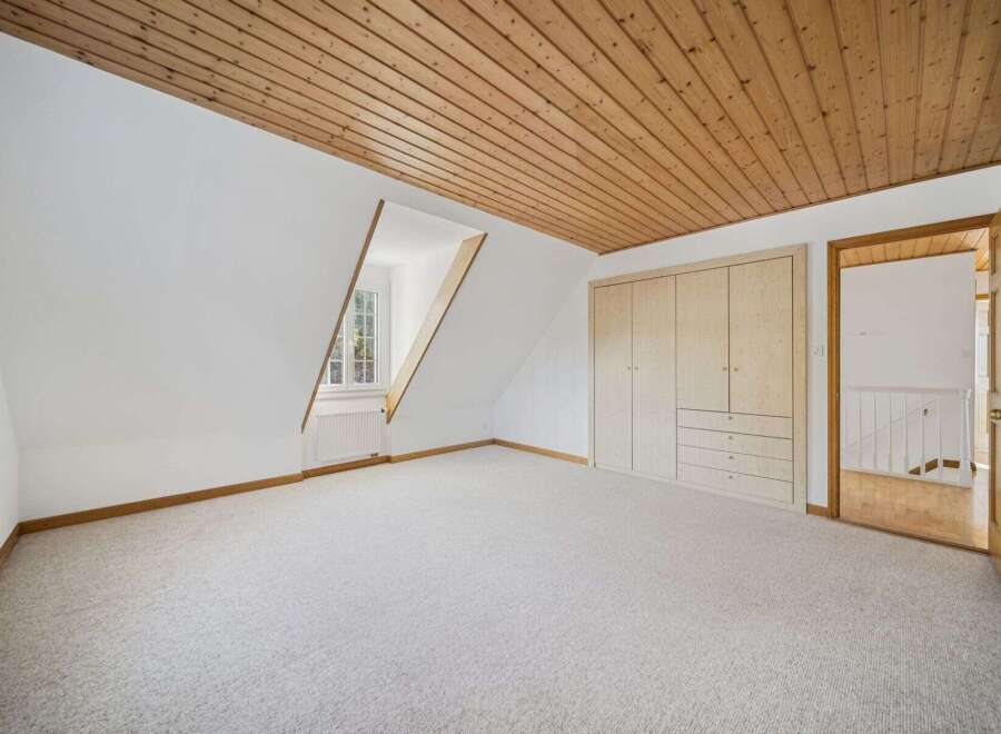Discover the charm of this inviting room, featuring a unique sloped ceiling and a cozy ambiance.