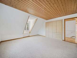 Discover the charm of this inviting room, featuring a unique sloped ceiling and a cozy ambiance.