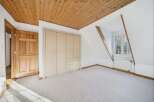 This stunning room features a beautiful wooden ceiling and a spacious built-in closet, offering ample storage.