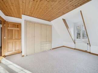 This stunning room features a beautiful wooden ceiling and a spacious built-in closet, offering ample storage.