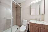 This modern bathroom features a sleek glass shower enclosure, perfect for a refreshing start to your day.