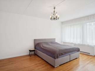 This inviting bedroom features a comfortable bed with a stylish headboard, perfect for relaxation.