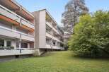 Discover this charming apartment building featuring spacious balconies and a lush green lawn.