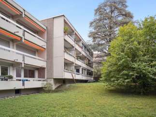 Discover this charming apartment building featuring spacious balconies and a lush green lawn.
